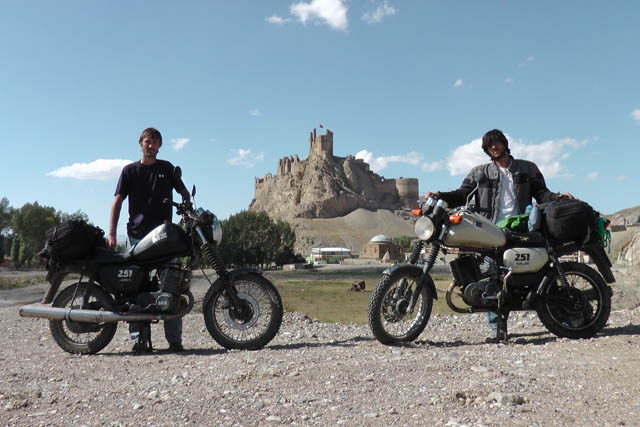 Matthew VanDyke and Daniel Britt with their MZ Kanuni motorcycles and Hosap Castle in the background in Guzelsu Turkey