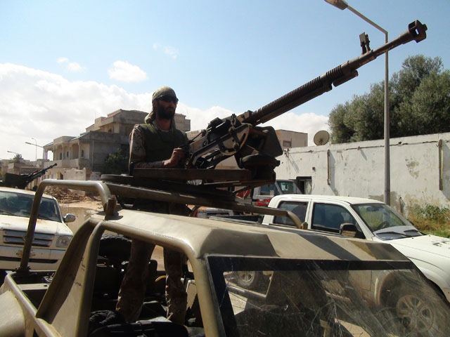 Freedom fighter Matthew VanDyke with a DShK heavy machine gun in the turret of his KADBB Desert Iris jeep during a mission with the Ali Hassan al-Jaber Brigade in Sirte Libya
