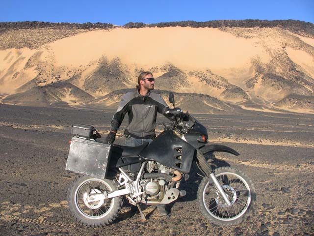 Matthew VanDyke with his Kawasaki KLR650 motorcycle in the Black Desert of Egypt