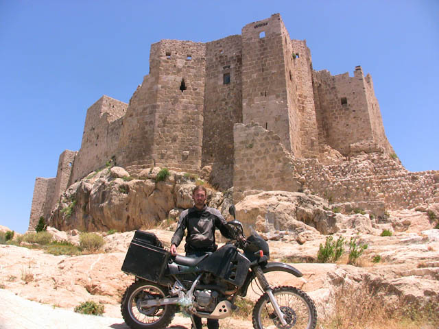 Matthew VanDyke with his Kawasaki KLR650 motorcycle at the Castle of Assassins in Musyaf Syria