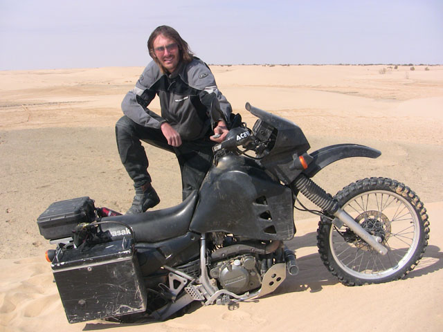 Matthew VanDyke with his Kawasaki KLR650 motorcycle stuck on a sand dune in Tunisia