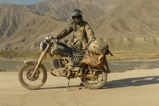 Matthew VanDyke and his MZ Kanuni motorcycle covered in dust after driving off-road near Pol-e Khomri Afghanistan