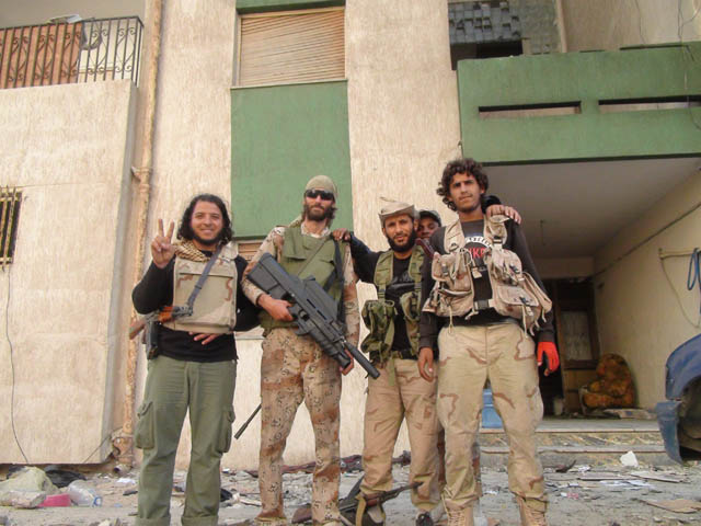Freedom fighter Matthew VanDyke with his FN F2000 assault rifle and a group of rebels in Sirte Libya