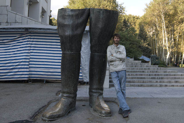Matthew VanDyke next to the destroyed statue of Reza Shah at Saadabad Palace in Tehran Iran