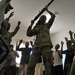 Matthew VanDyke dancing with Libyan rebels while holding a gun in a scene from the film Point and Shoot