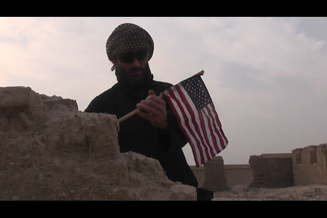adventurer matthew vandyke placing an american flag in osama bin laden house in jalalabad afghanistan