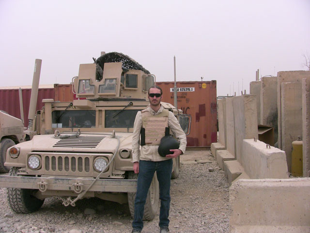 journalist matthew vandyke working as a war correspondent next to a military humvee at fob marez in mosul iraq